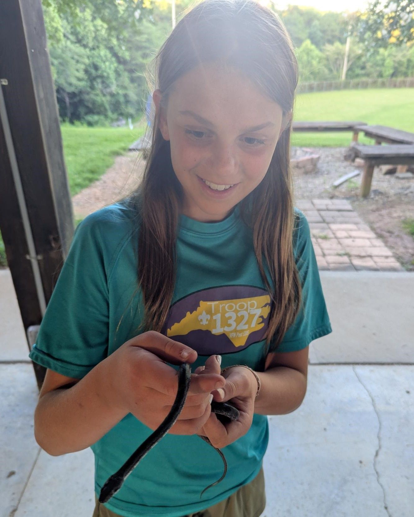 A girl in a virginia shirt is holding a snake