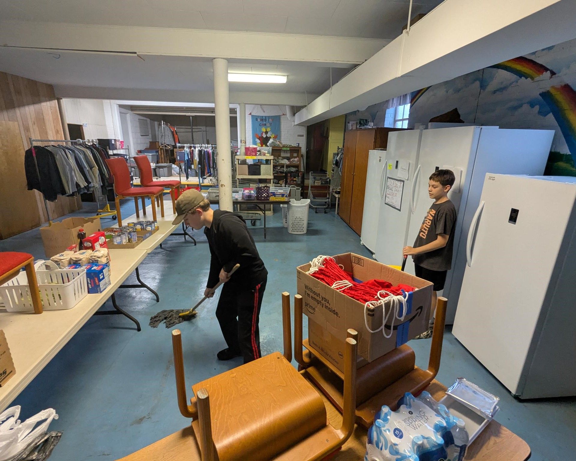 A man is cleaning a room with a mop.