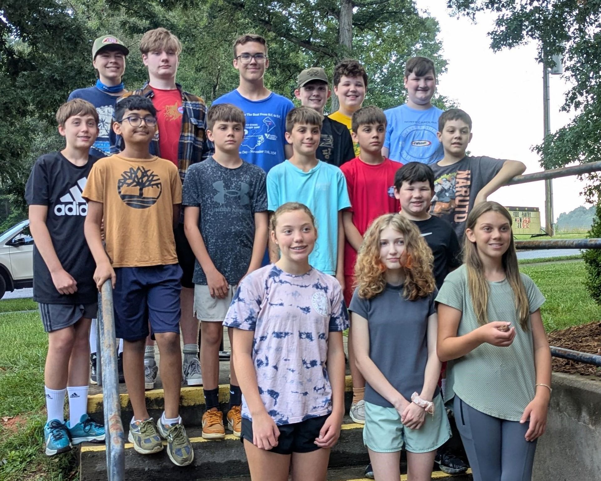 A group of young people are posing for a picture on a set of stairs.