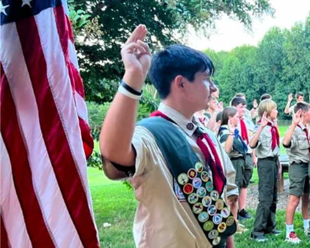 Boy scouts standing in front of an american flag