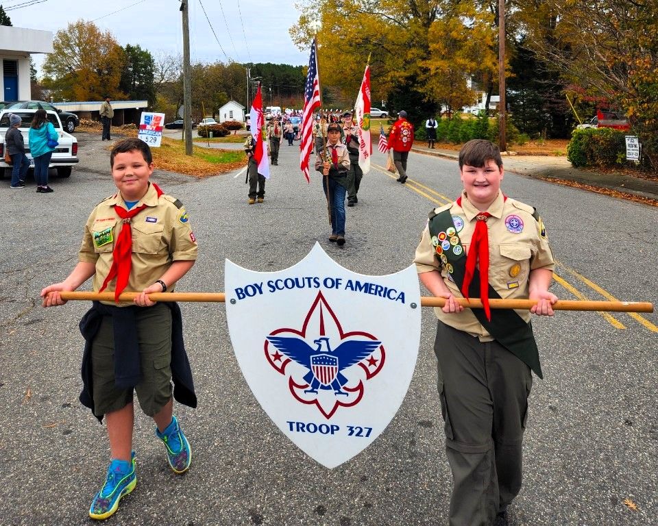 Boy scouts of america are marching down the street