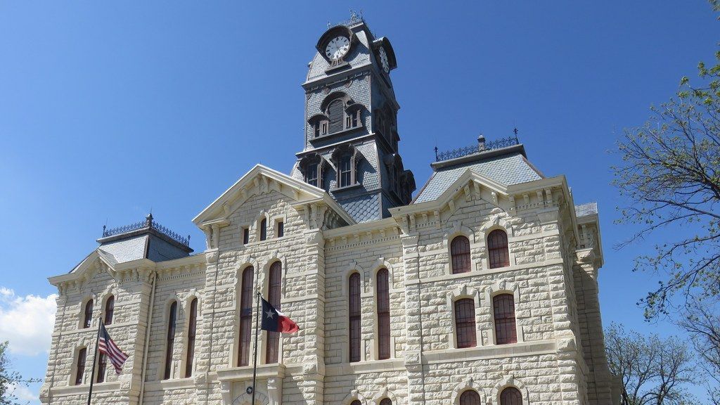 A large stone building with a clock tower on top of it.