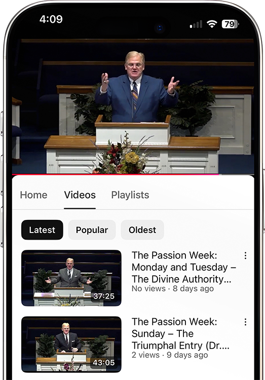 A man is standing at a podium giving a speech on a cell phone.