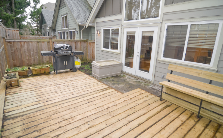 A photo of a small deck recently installed at a home in Lubbock, TX. The deck sits low to the ground, so there is no need for a railing to be present.