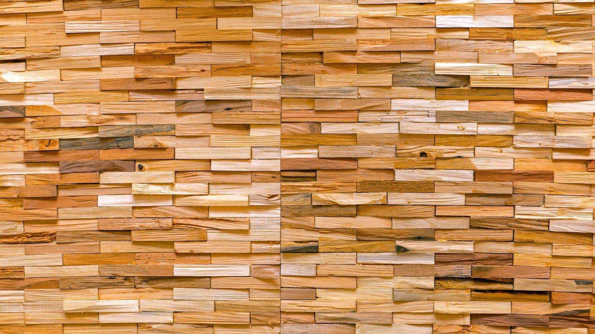 Close-up of an intricately patterned wall made from an assortment of wooden blocks of different sizes and shades, showcasing sustainable material use in Lubbock, Texas. The natural tones range from pale beiges to deep browns, creating a tapestry of wood that is both visually appealing and environmentally conscious. This image could represent the use of reclaimed or eco-friendly wood in construction, aligning with green building trends in Lubbock's architecture and design industry.