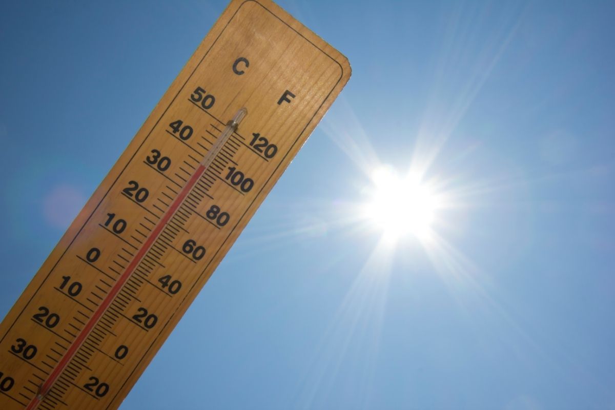 This photo captures a thermometer with Celsius and Fahrenheit scales against the backdrop of a bright blue sky in Lubbock, TX. The sun blazes in the center, emitting strong rays of light, suggestive of high temperatures typical of Texas weather. The thermometer's mercury level is not visible, but the implication of heat is conveyed by the clear, sunlit sky. The image effectively portrays a scorching sunny day, likely prompting locals to seek shade and hydration.