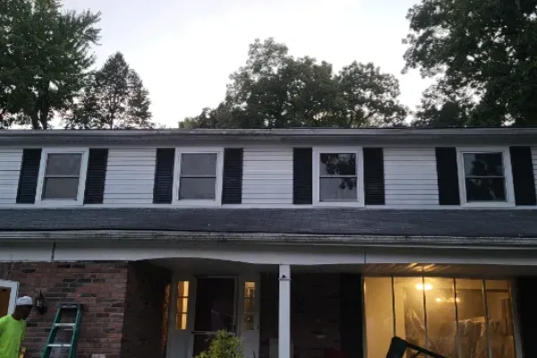 A white house with black shutters on the windows. A white house with black shutters on the windows.