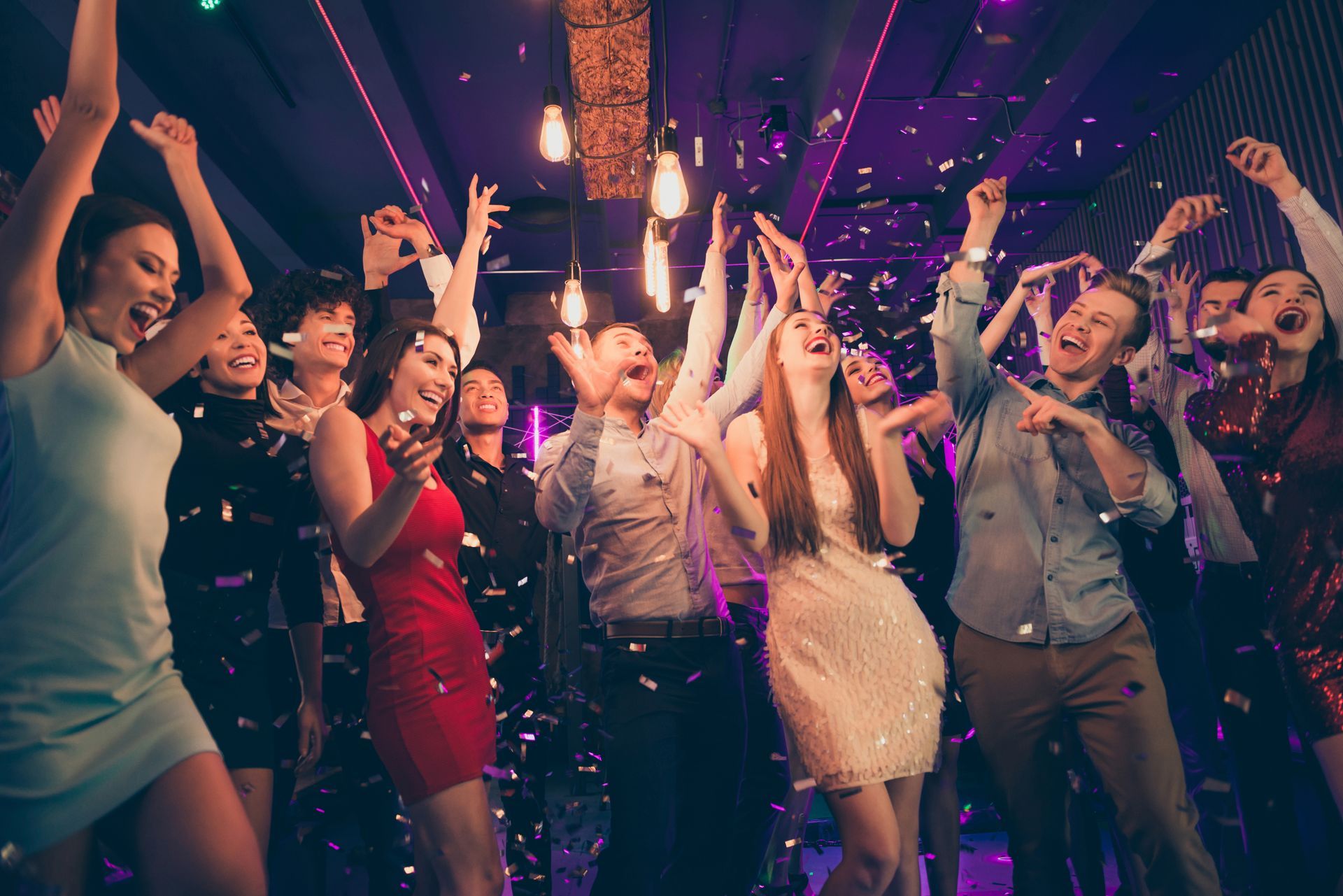 A group of people are dancing at a party in a club.