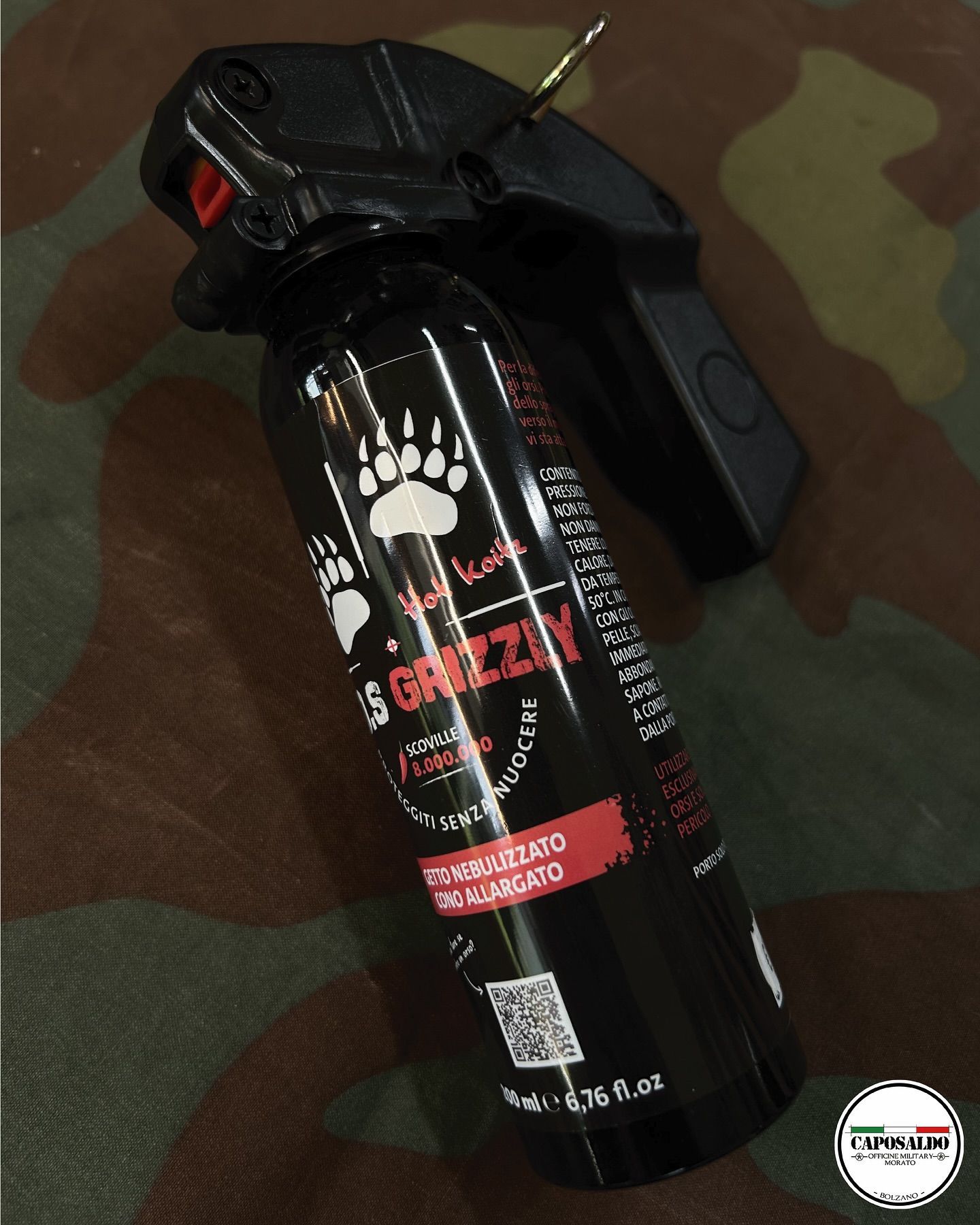 Bomboletta spray nera con logo a forma di artiglio d'orso su sfondo mimetico