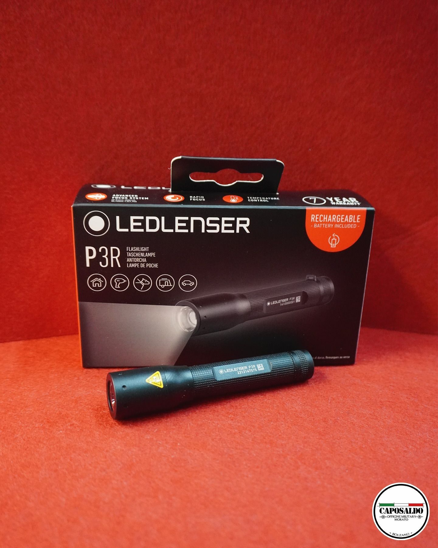 Torcia LEDLENSER P3R in scatola nera, con luce blu visualizzata su sfondo rosso.