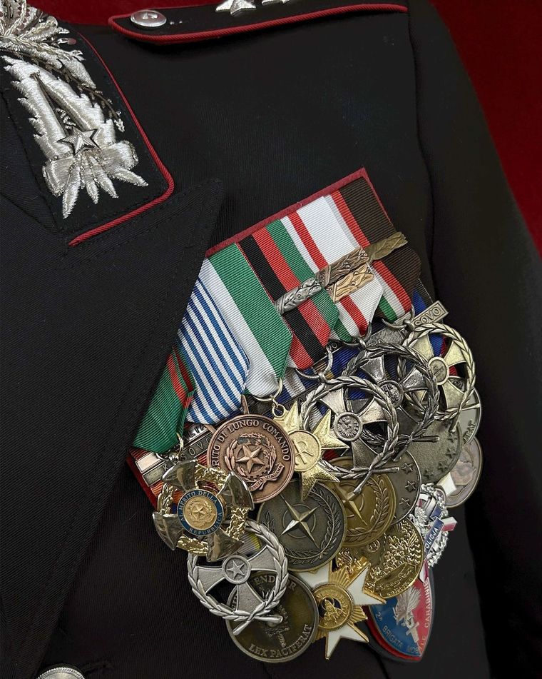 Pettorina dell'uniforme militare con medaglie e nastri colorati su una giacca nera.