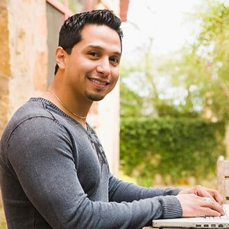 Man Working on a Laptop and Smiling — Health Insurance in Bozeman, MT Man Working on a Laptop and Smiling — Health Insurance in Bozeman, MT
