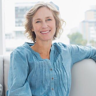 Happy Woman Relaxing on Her Couch — Health Insurance in Bozeman, MT Happy Woman Relaxing on Her Couch — Health Insurance in Bozeman, MT