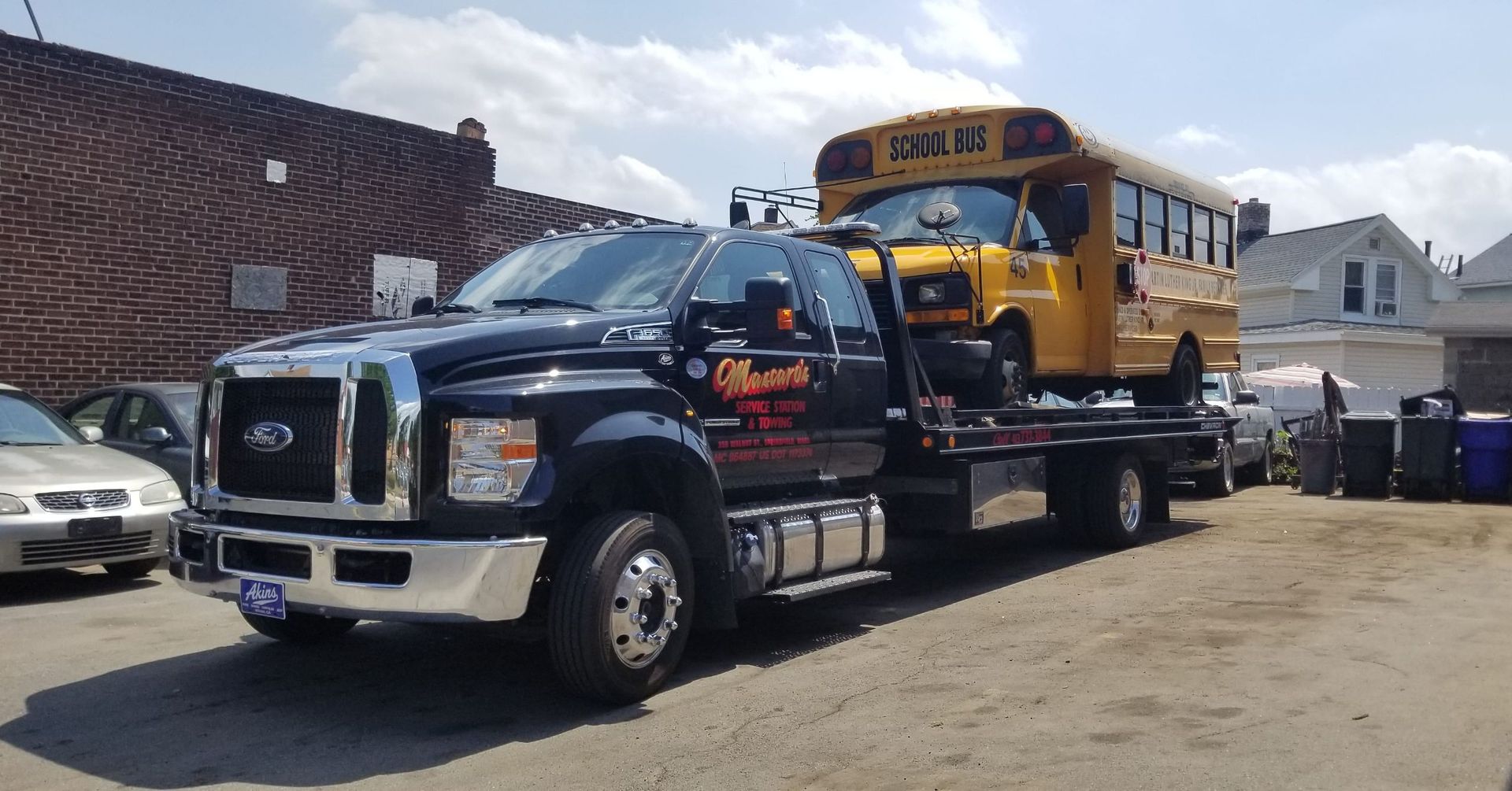 A school bus is being towed by a tow truck