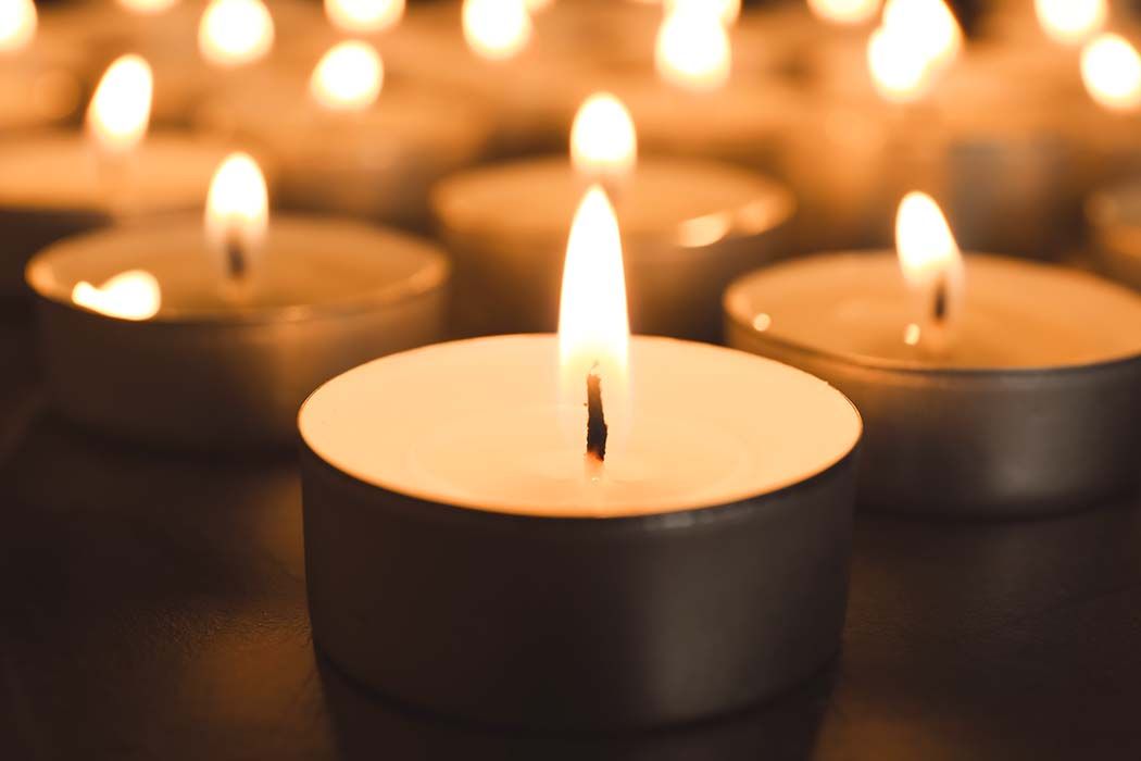 Lit tea light candles, close-up and blurred background, creating a warm, glowing ambiance.