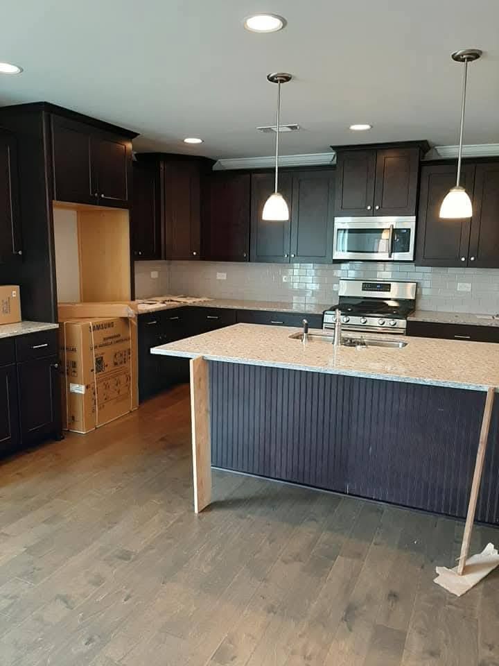 An empty kitchen with a large island in the middle