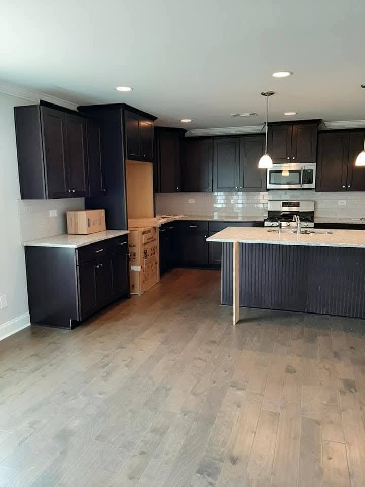A kitchen with black cabinets and a white counter top