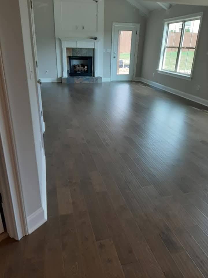 A living room with hardwood floors and a fireplace.