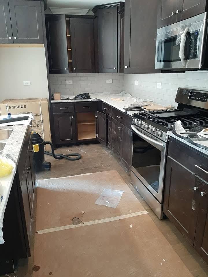 A kitchen with stainless steel appliances and wooden cabinets is being remodeled.