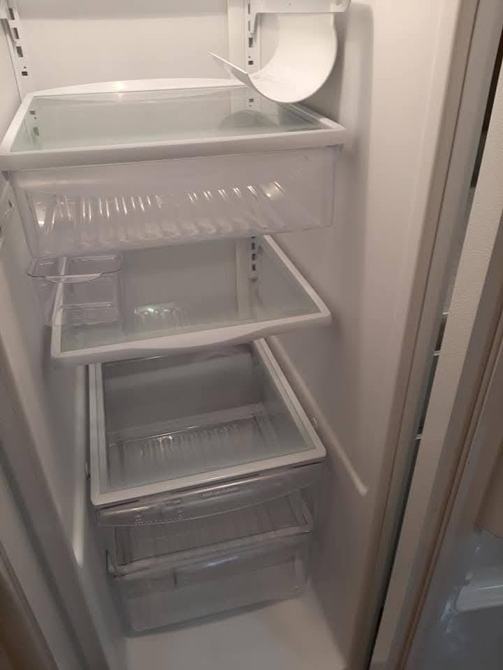 The inside of a refrigerator with empty shelves and drawers.