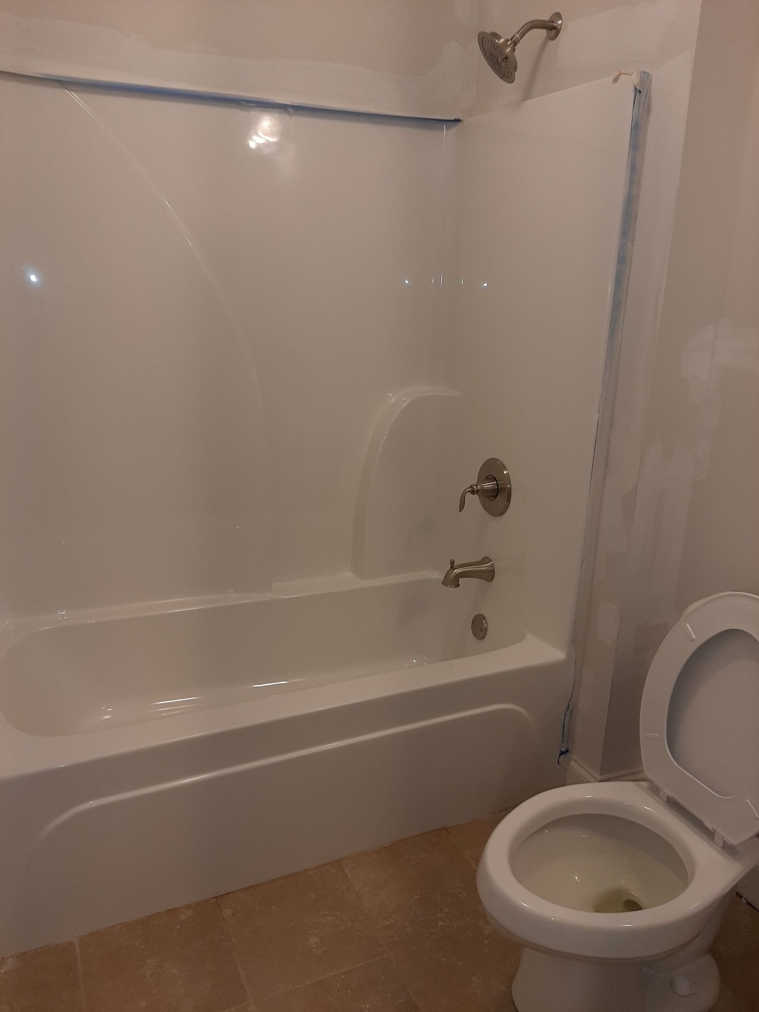 A bathroom with a toilet , bathtub and shower.