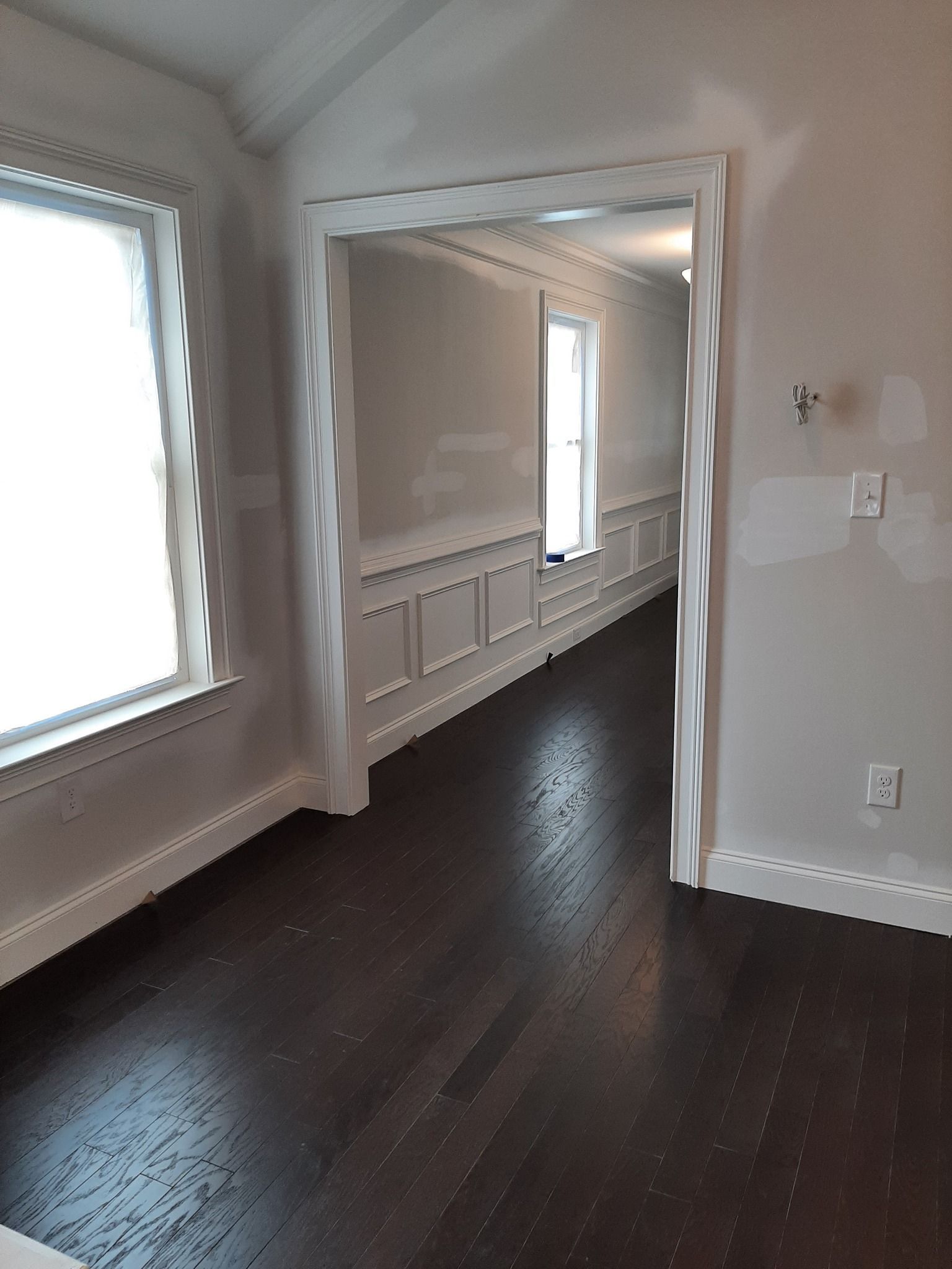 An empty room with hardwood floors and white walls.