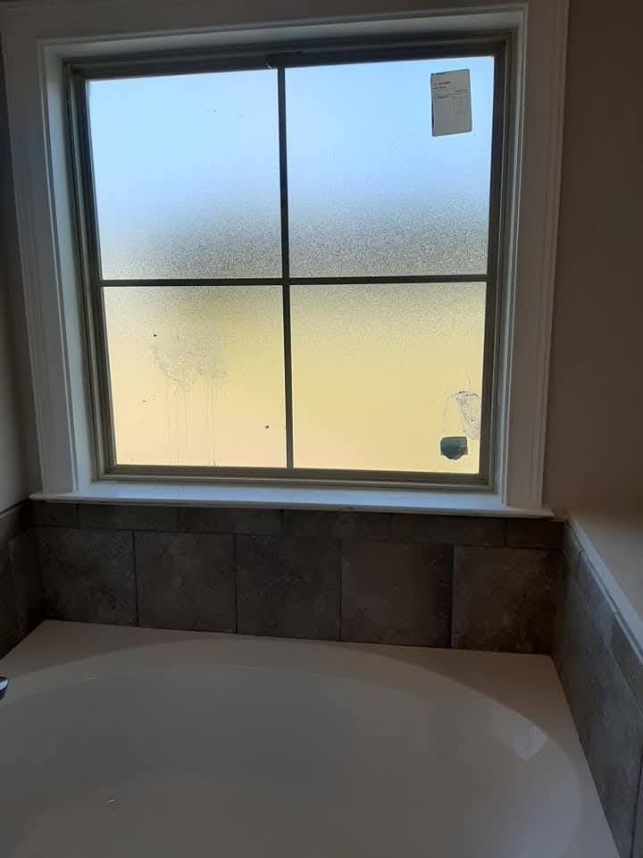 A bathroom with a bathtub and a window.