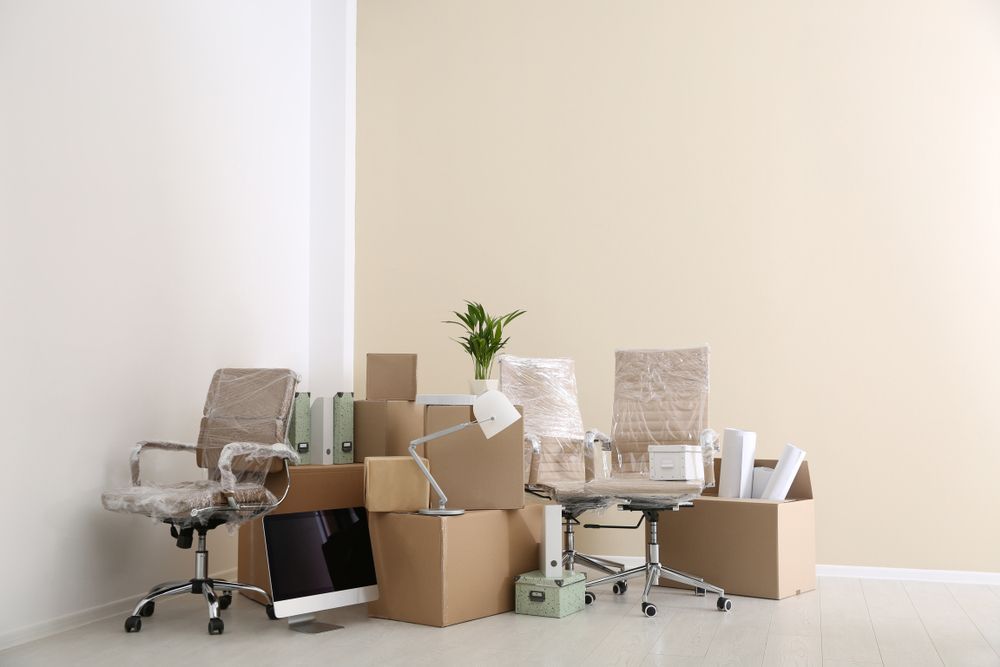 Office Furniture and Boxes Stacked in a Corner — Lite Moves Furniture Removals In Sydney, NSW