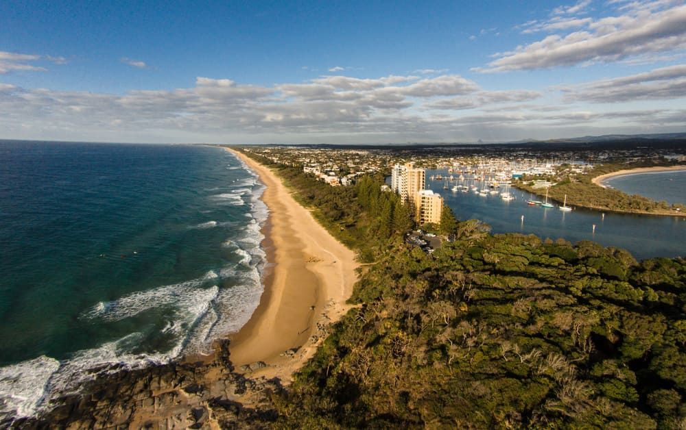 An Aerial View of A Beach Surrounded by Trees and A Body of Water — Lite Moves Furniture Removals In Bonville, NSW