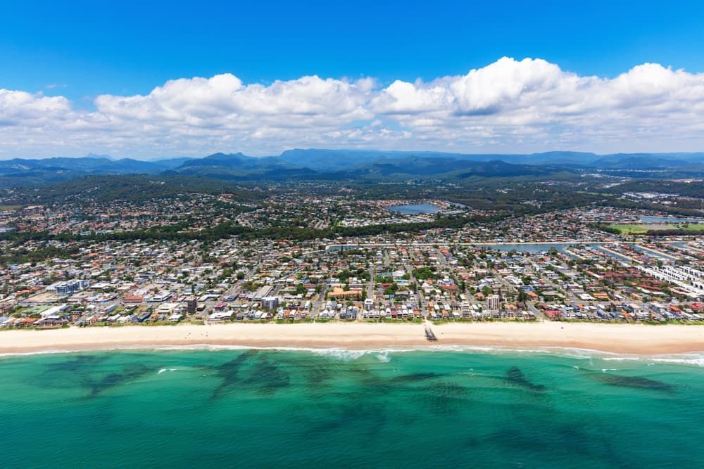 An Aerial View of A Beach with A City in The Background — Lite Moves Furniture Removals In Bonville, NSW
