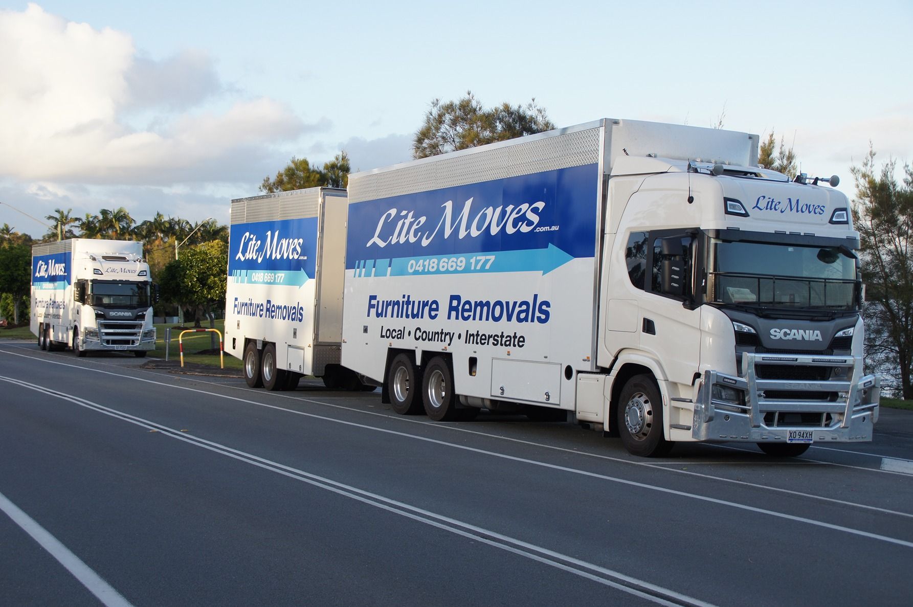 Man Holding A Moving Cardboard Box In Front Of A Storage Door — Lite Moves Furniture Removals In Bonville, NSW