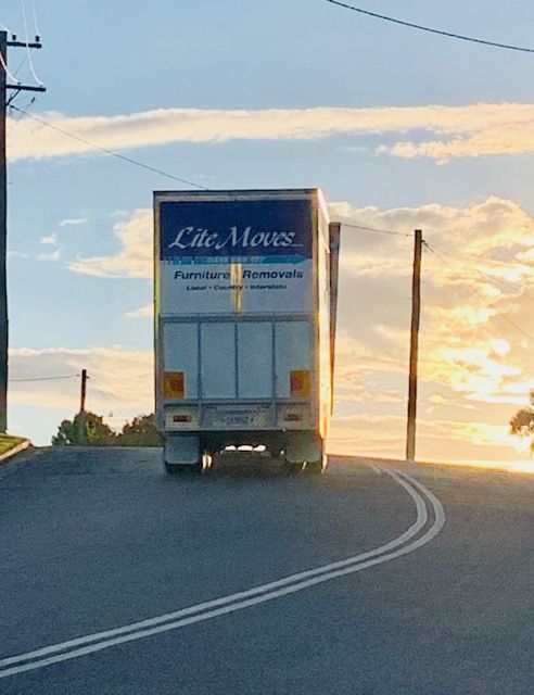 White Truck driving away - Lite Moves Furniture Removals In Bonville, NSW