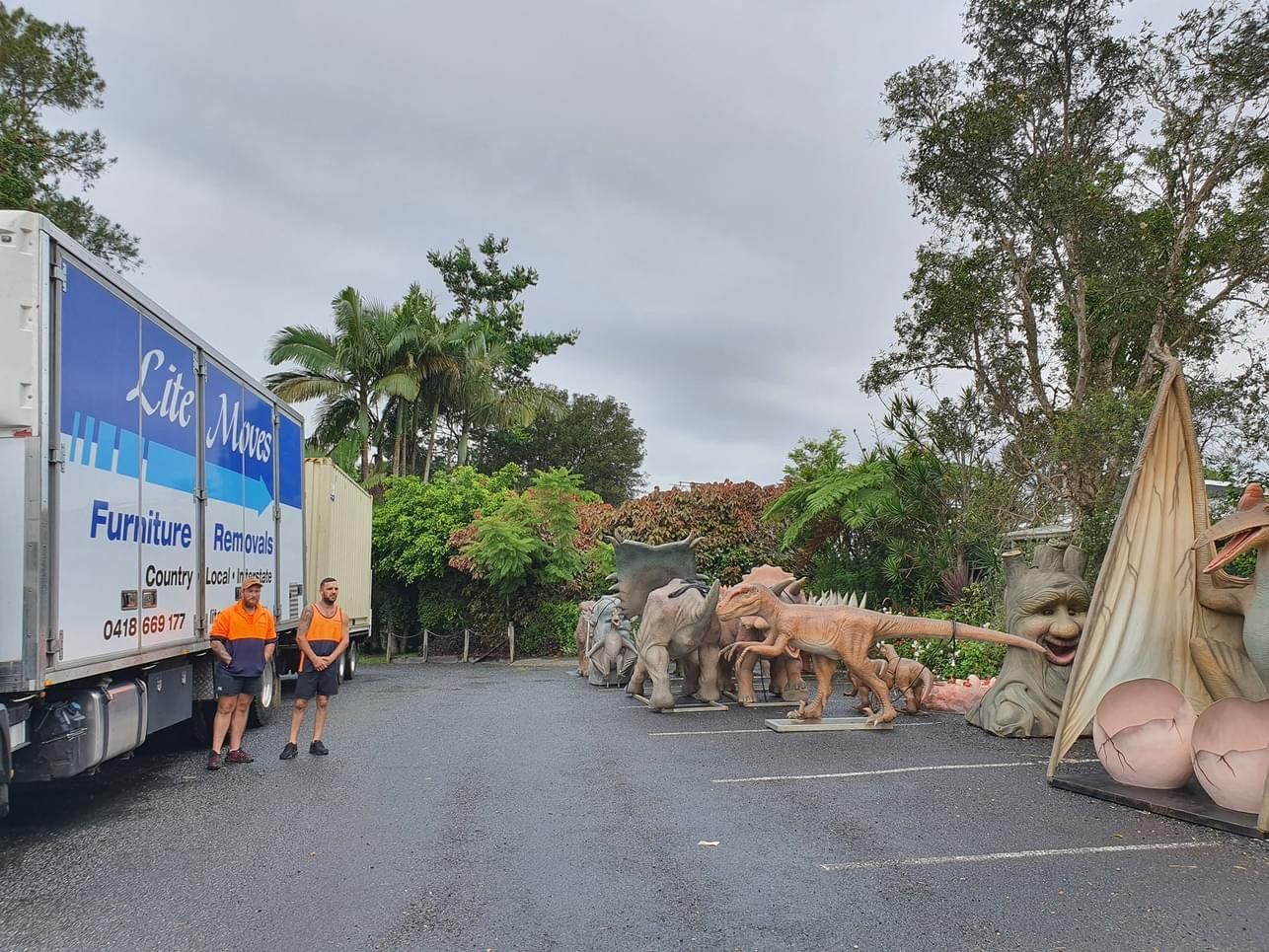 A Group of People Are Standing in Front of A Moving Truck — Lite Moves Furniture Removals In Coffs Harbour, NSW