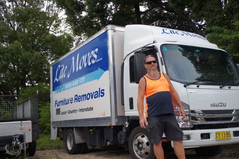 Mover With The Orange Uniform standing in front of White Truck — Lite Moves Furniture Removals In Bonville, NSW