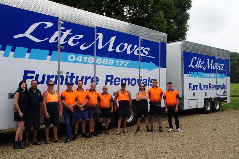 Team of 11 crew members standing in front of their Lite Moves Truck with a trailer - Lite Moves Furniture Removals In Bonville, NSW