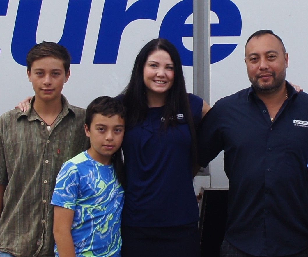 Family of four standing in front of truck — Lite Moves Furniture Removals In Bonville, NSW