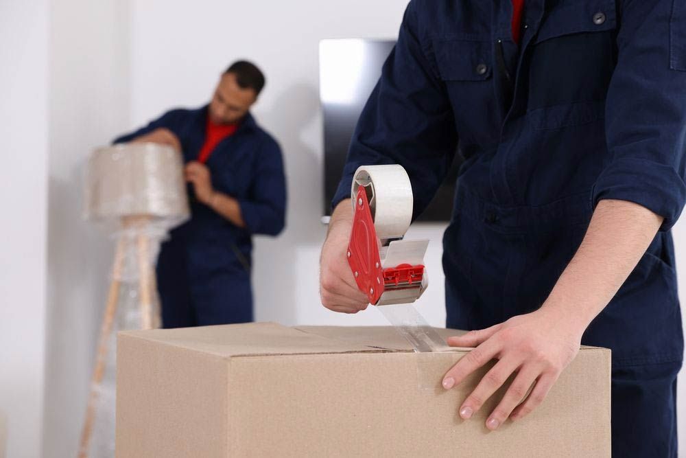 Removalist Adding Tape To A Moving Box