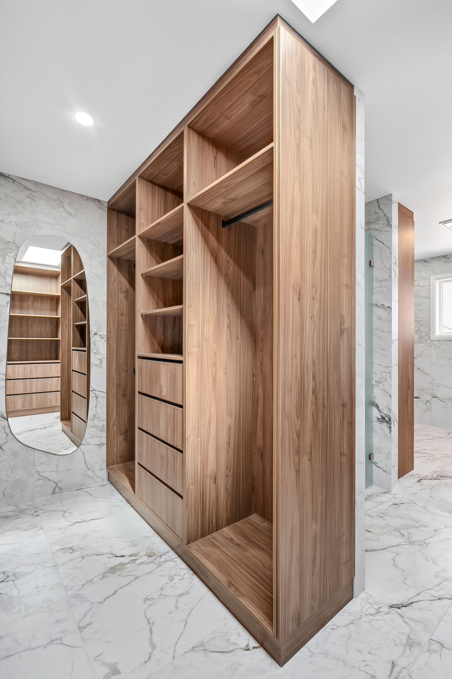 Wooden walk-in closet with shelves, drawers, and hanging rod. Marble floors and walls. Mirror reflects additional storage — PK4 Projects in Port Macquarie, NSW