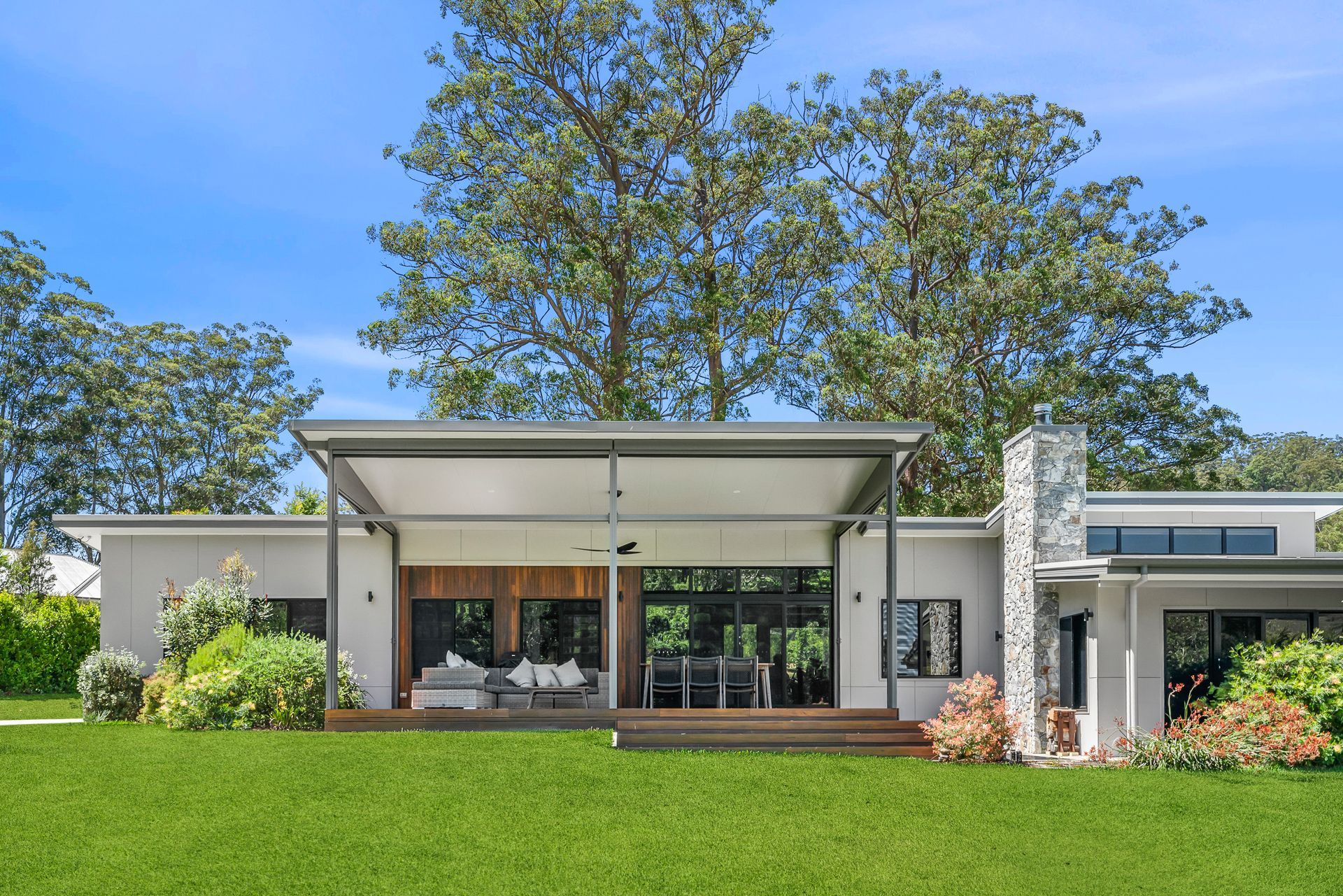 An eye-line view of the outdoor area of a house with lawn in front of it and tress at the back — PK4 Projects in Port Macquarie, NSW