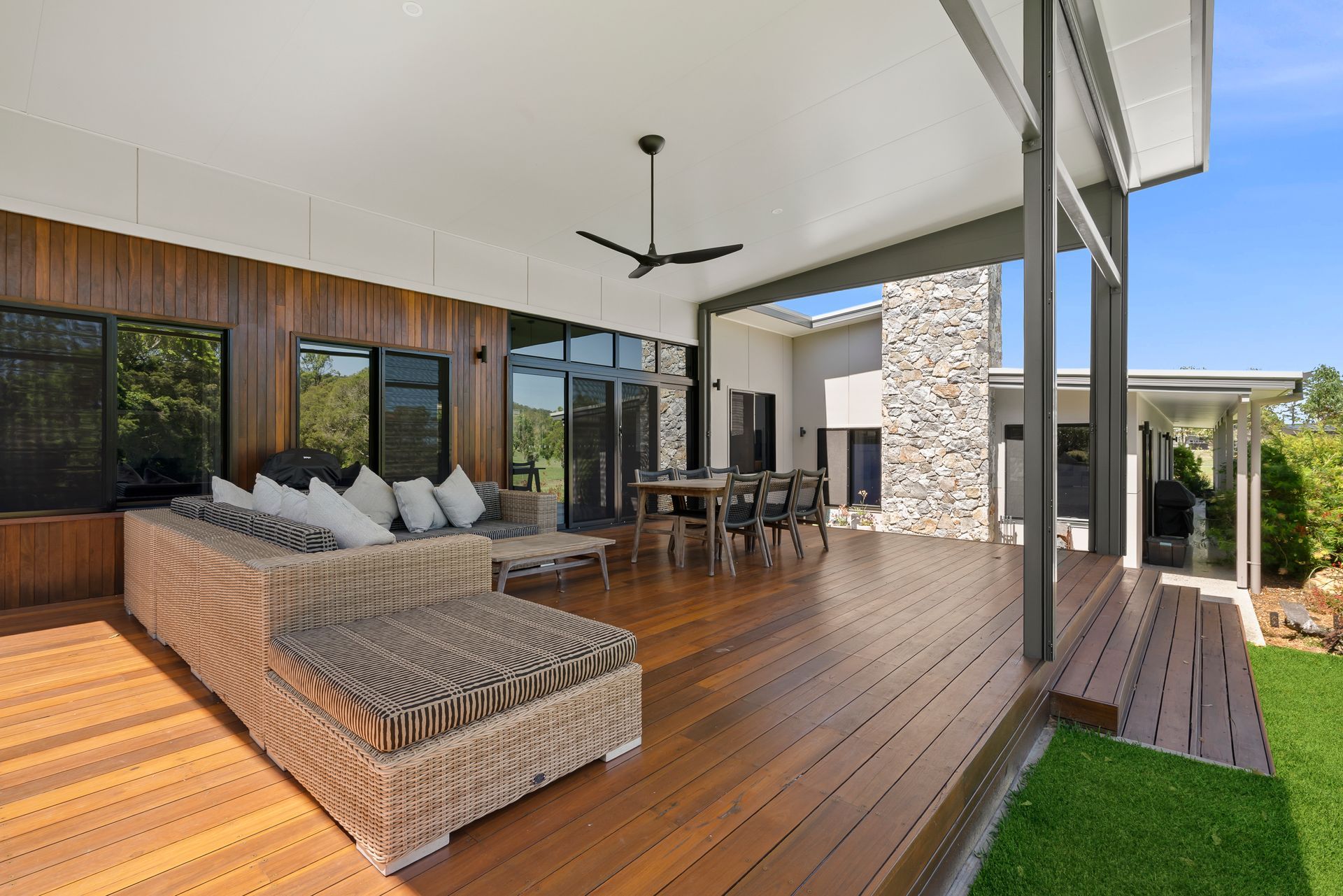 An outdoor area with wooden floors, a ceiling fan, couch set and a table — PK4 Projects in Port Macquarie, NSW