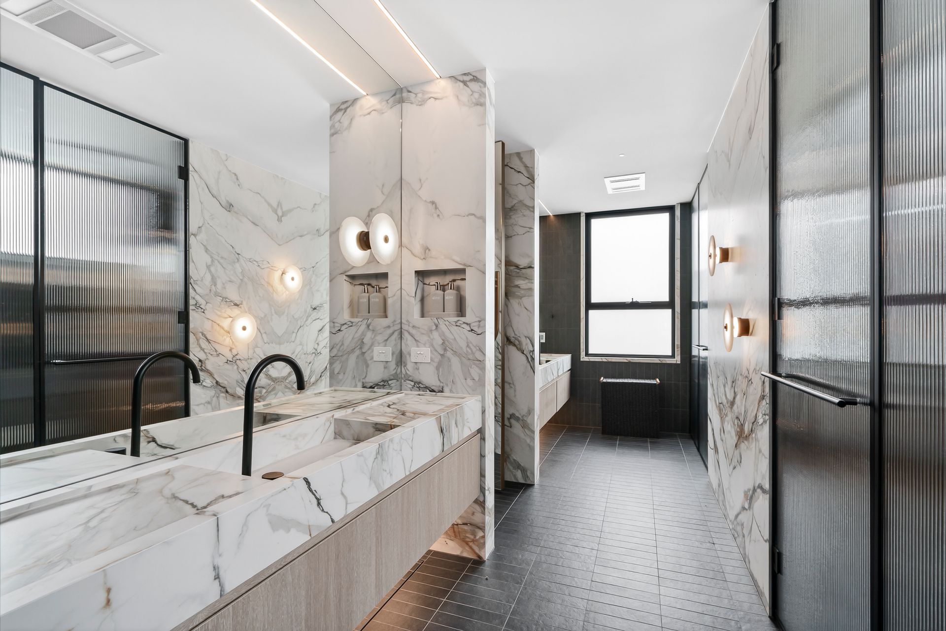 Luxurious bathroom with marble walls, a long vanity, and a black floor  — PK4 Projects in Port Macquarie, NSW