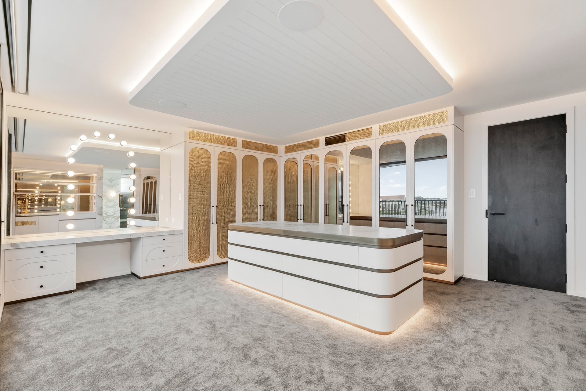 Spacious luxury walk-in closet with white cabinets, ornate gold detailing, and a central island with a grey countertop. — PK4 Projects in Port Macquarie, NSW