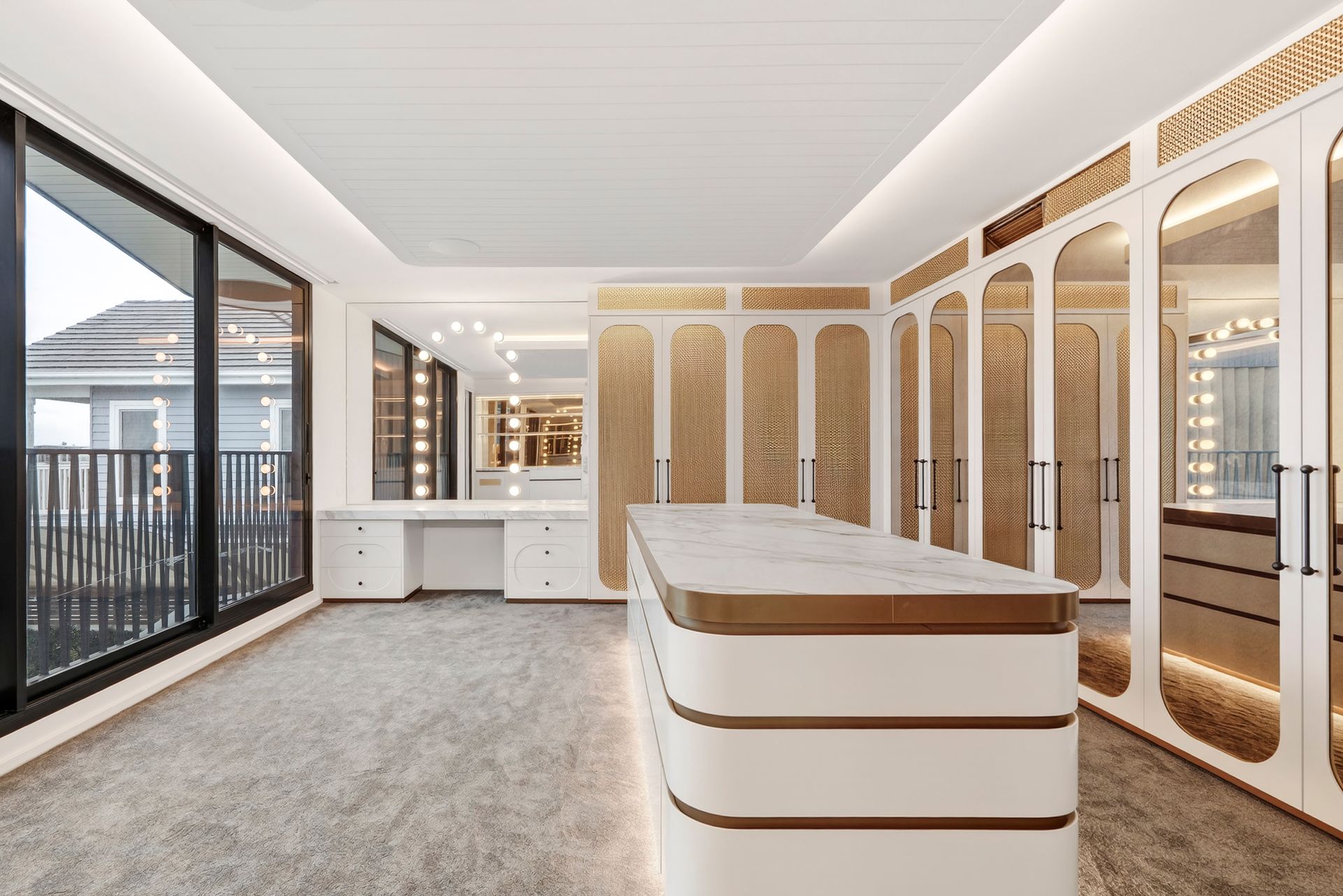 Luxurious white walk-in closet with gold accents, island, and large windows overlooking a balcony  — PK4 Projects in Port Macquarie, NSW