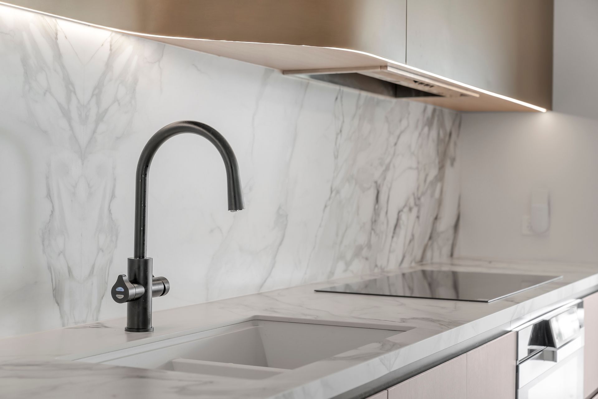 Modern kitchen with marble backsplash, black faucet, and built-in stovetop — PK4 Projects in Port Macquarie, NSW