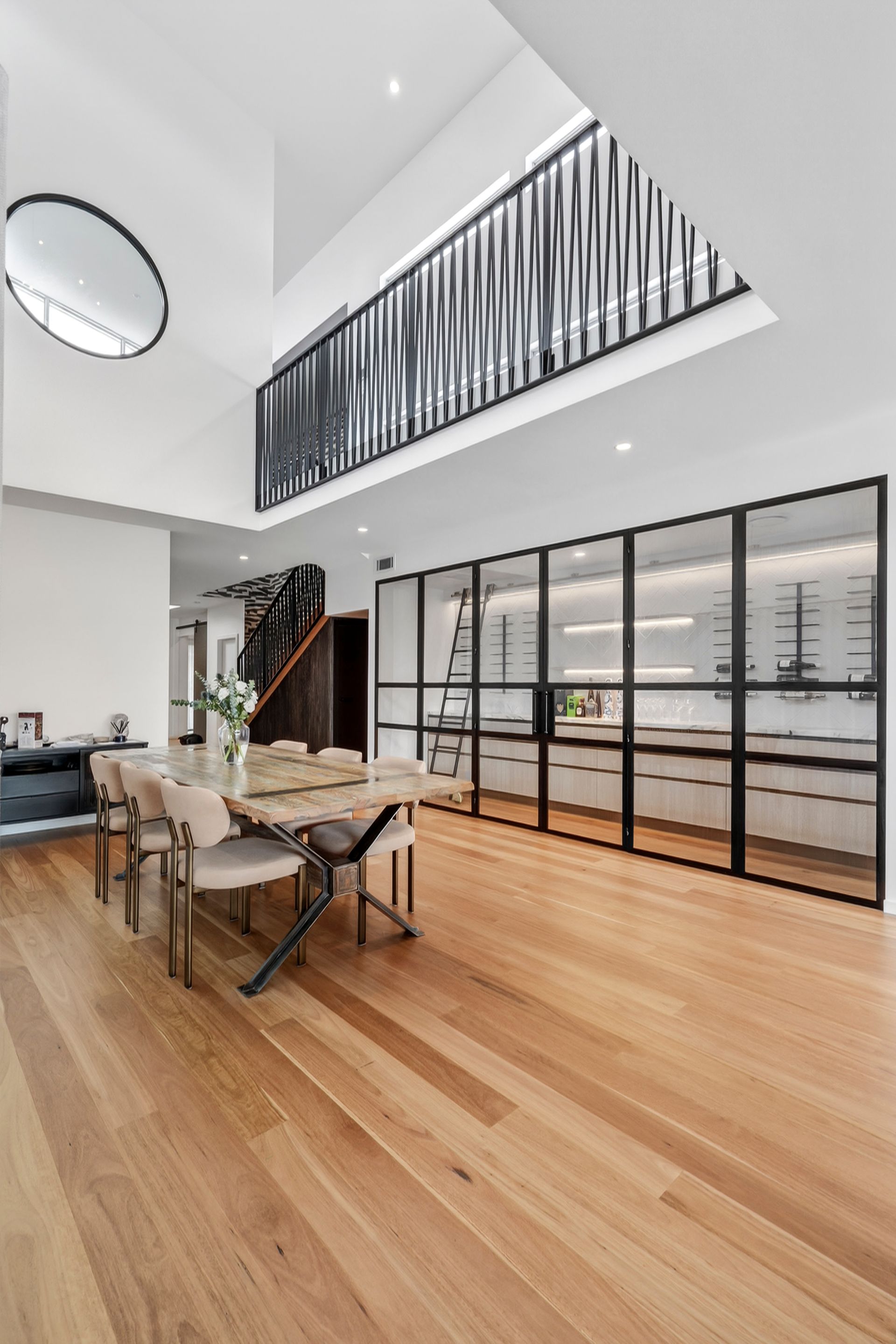 Spacious dining area with wood floors, glass wine cellar, and high ceiling. — PK4 Projects in Port Macquarie, NSW