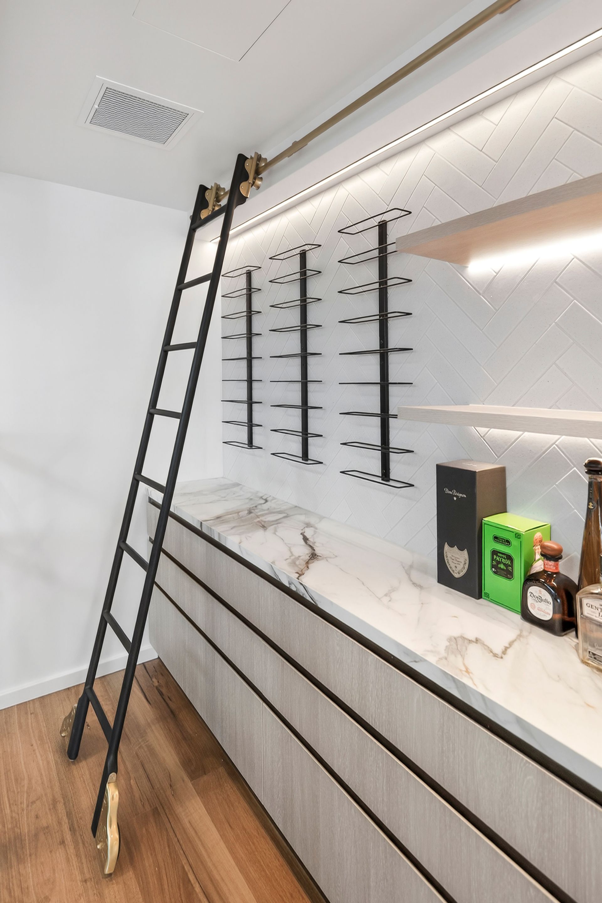 Black rolling ladder next to a wall display with eyewear and accessories. Marble countertop, light wood cabinets — PK4 Projects in Port Macquarie, NSW