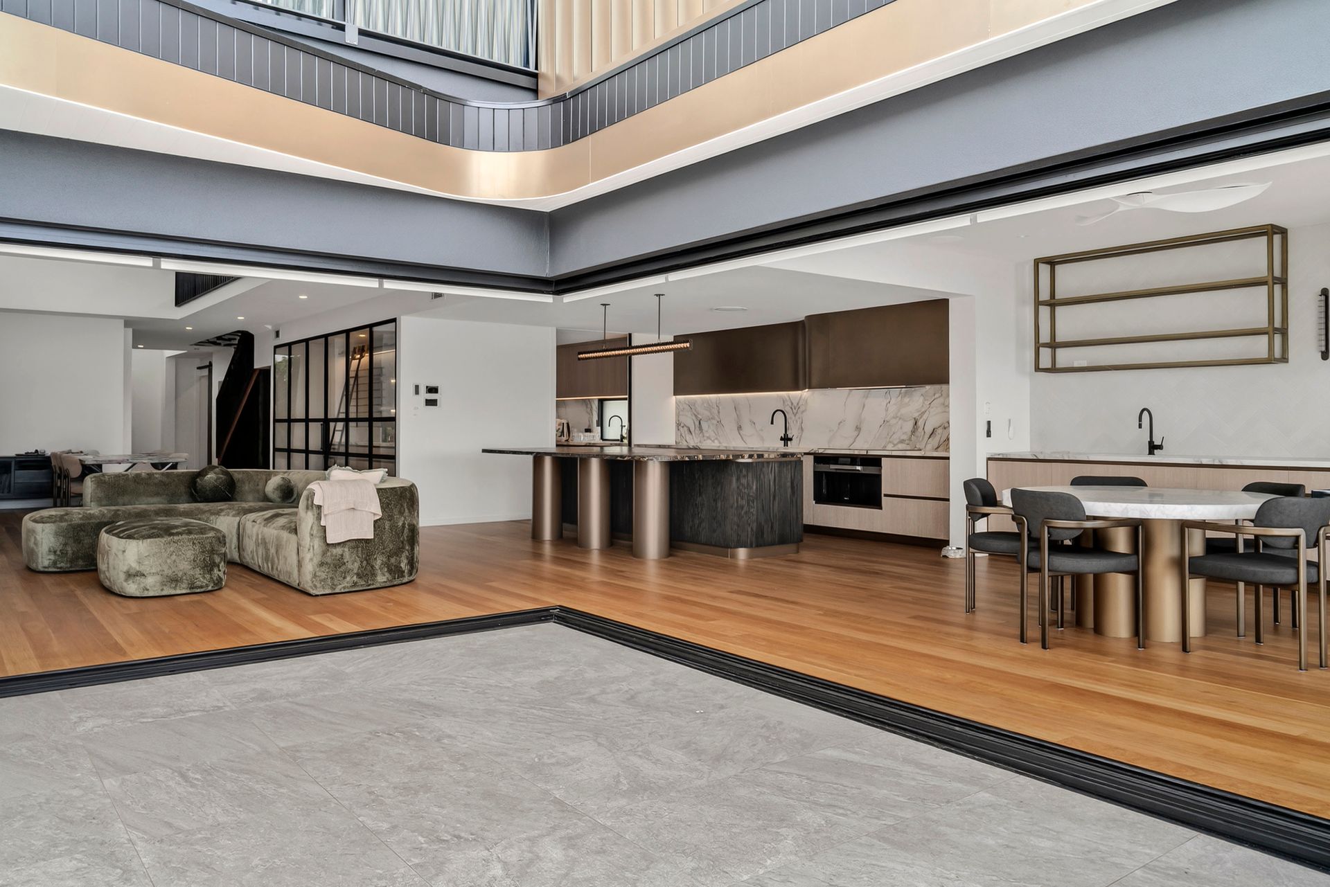 Modern open-plan living space with kitchen island, dining area, and plush sofa; light wood floors, neutral tones. — PK4 Projects in Port Macquarie, NSW