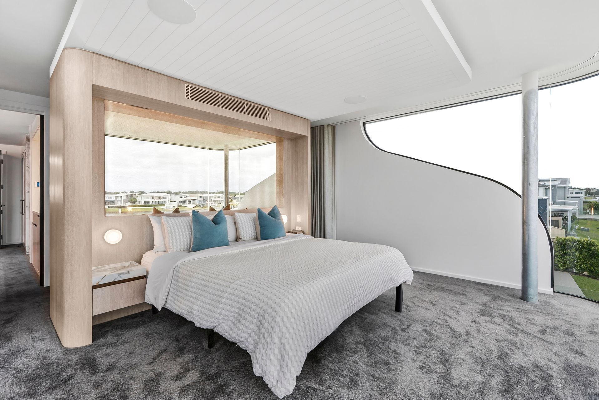 Modern bedroom with bed, large window, built-in bench, gray carpet, and teal pillows. — PK4 Projects in Port Macquarie, NSW