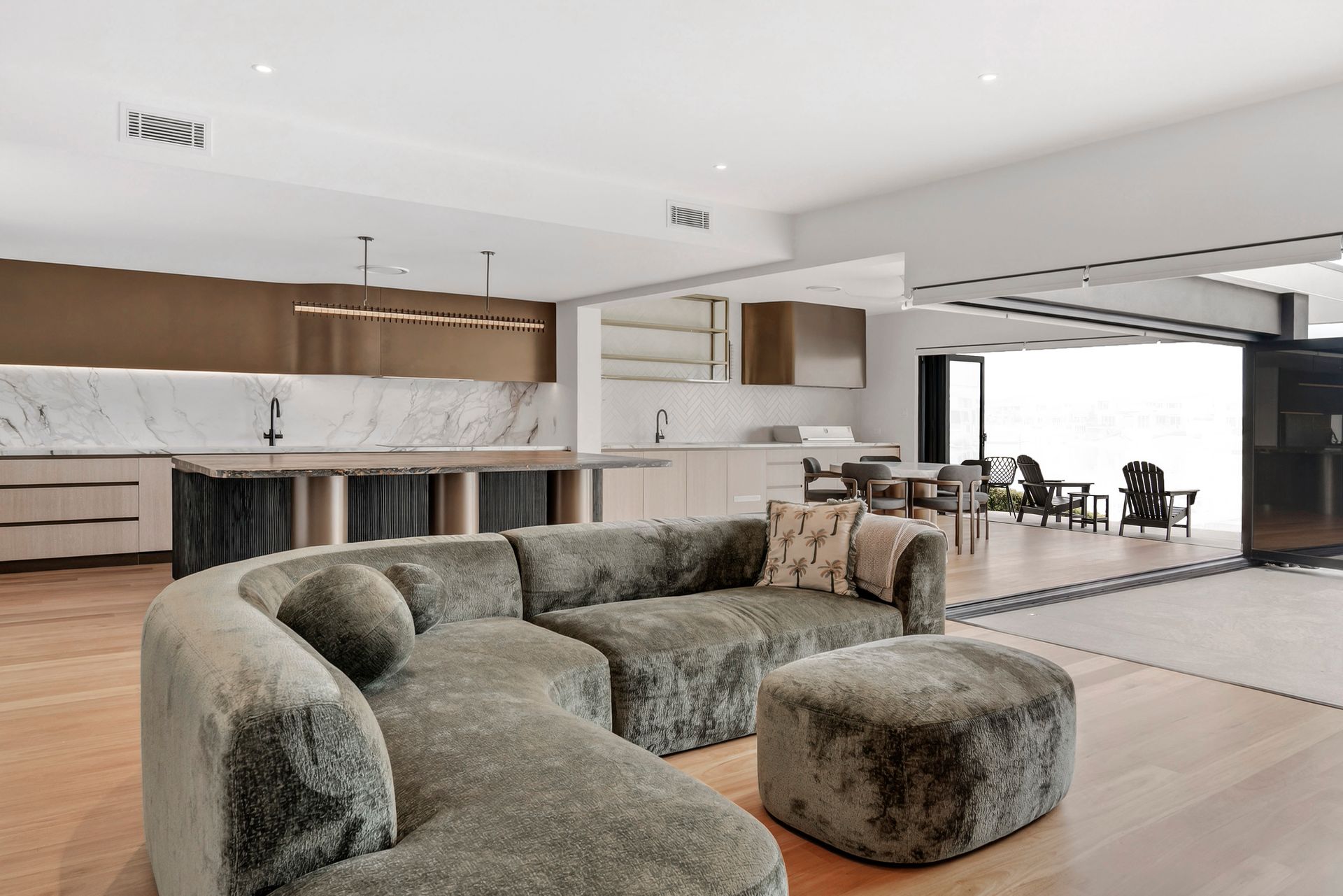 Modern living room with a fluffy sectional sofa, open to a kitchen and dining area  — PK4 Projects in Port Macquarie, NSW
