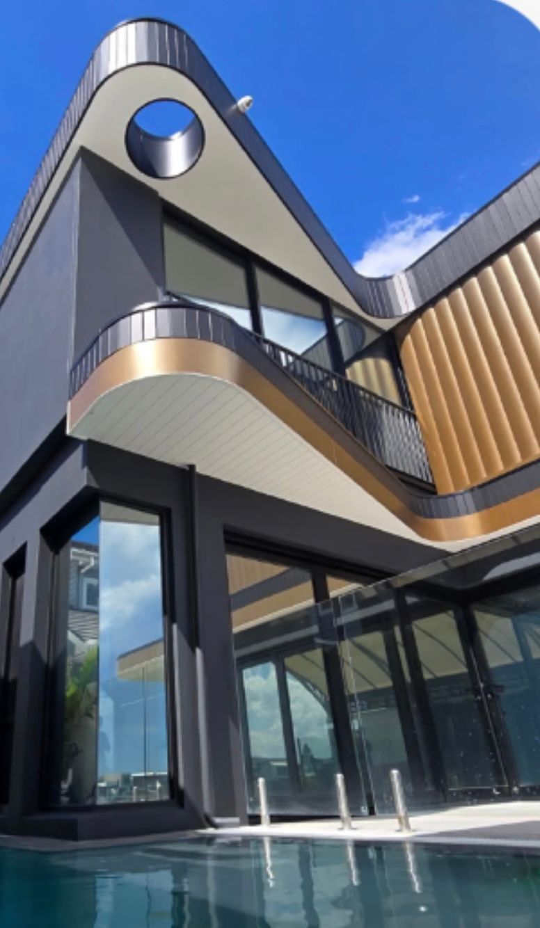 Modern house with black, gold, and white accents, curved roof, glass windows, and a pool on a sunny day — PK4 Projects in Port Macquarie, NSW